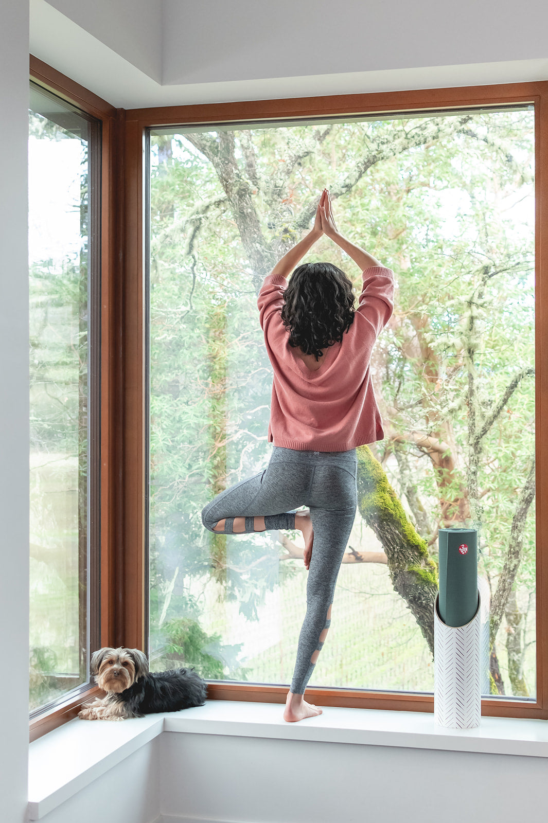 Homi yoga mat storage tube - Hatch (White) design - sitting on a window sill with yogi & her dog next to it - Mache | Eco Yoga Store