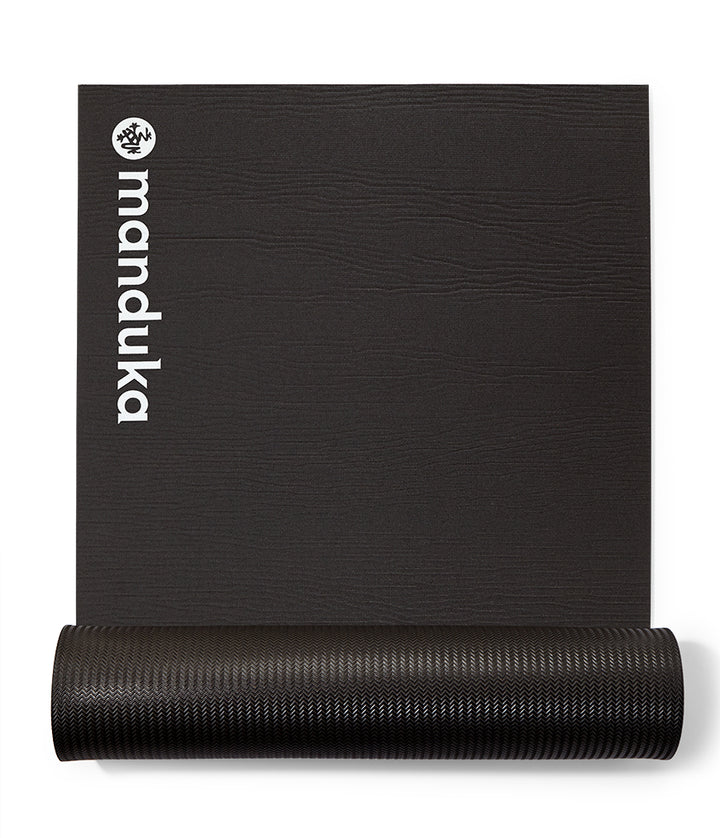 Manduka ENDURA Fitness Mat 10mm - Black - part rolled, overhead view, logo end | Eco Yoga Store