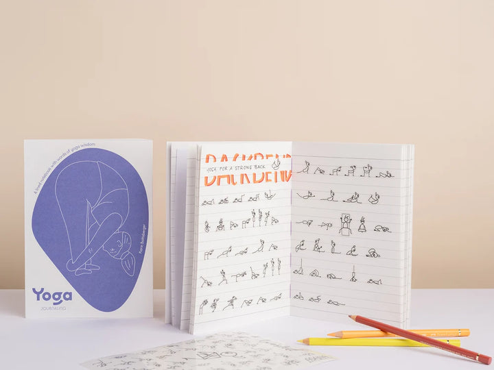 Two Yoga Journaling Notebooks displayed on a light beige background. On the left is a closed hardcover notebook with a white cover featuring a large blue-purple abstract shape and the word 'Yoga' - Yoga Journaling | Eco Yoga Store