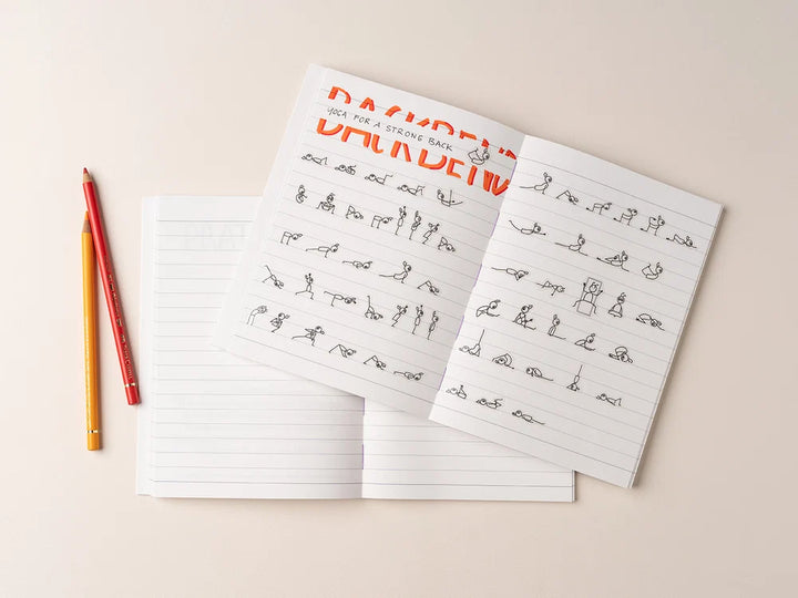 An open Yoga Journaling Notebook with handwritten notes and the word 'BACKBEND' printed in orange at the top, styled on a light beige background with two colored pencils - Yoga Journaling | Eco Yoga Store