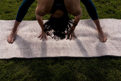 Move to Wool Movement Mat - lying on grass with yogi bending torso at waist with hands and feet on the mat - Move to Wool | Eco Yoga Store