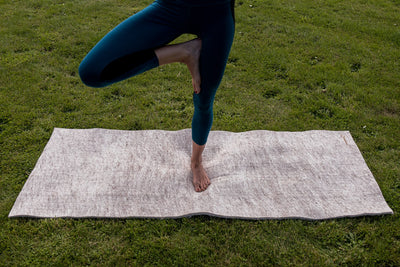 Move to Wool Movement Mat - lying on grass with yogi standing on one leg - Move to Wool | Eco Yoga Store