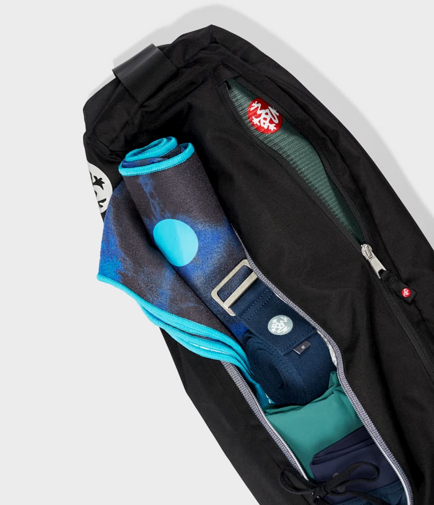 Manduka Go Steady 3.0 Mat Bag - Black - filled with yoga mat, strap & towel, zips half undone | Eco Yoga Store