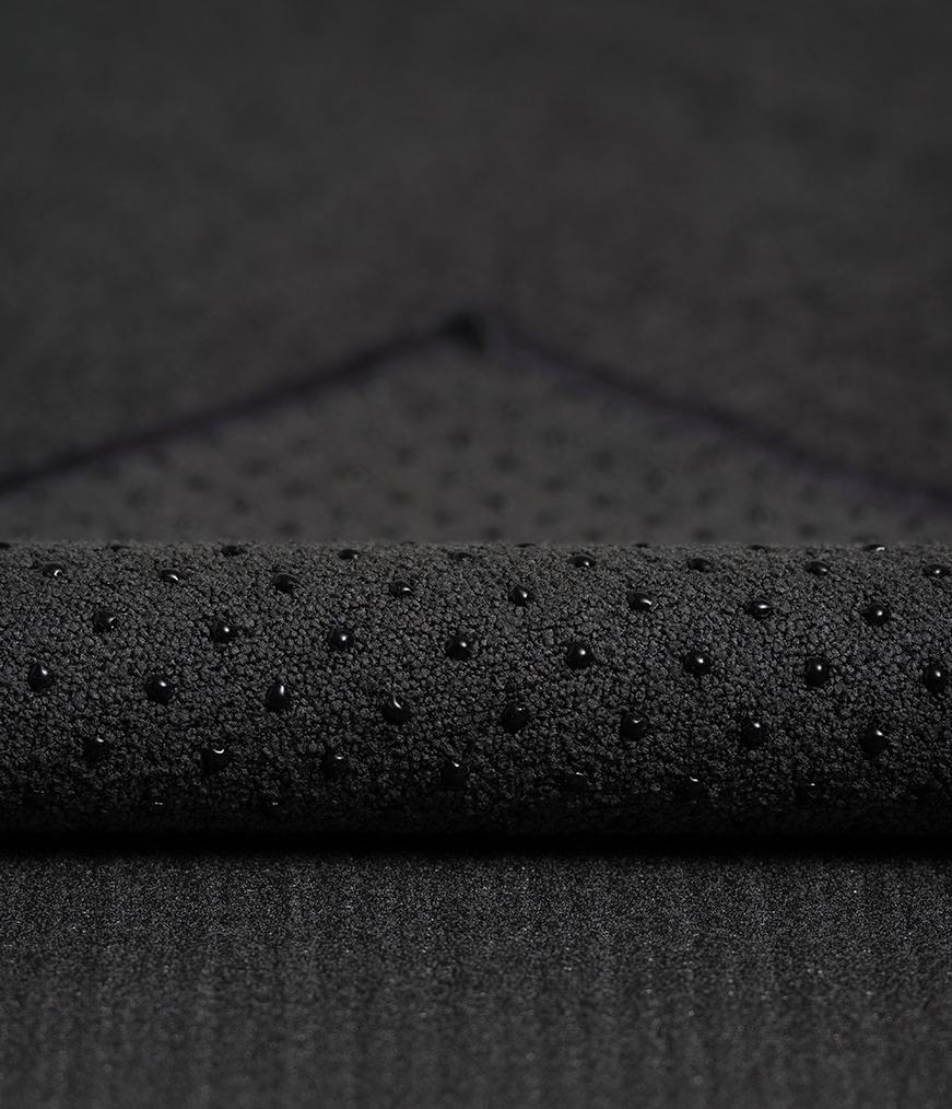 Manduka Yogitoes Mat Towel - Onyx - corner folded over showing underside | Eco Yoga Store